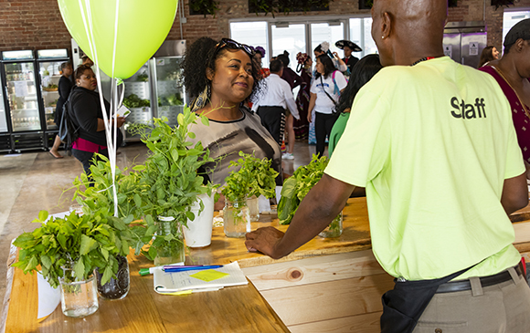 A customer gets information on the selection of herbs currently available at the Farm on Ogden.